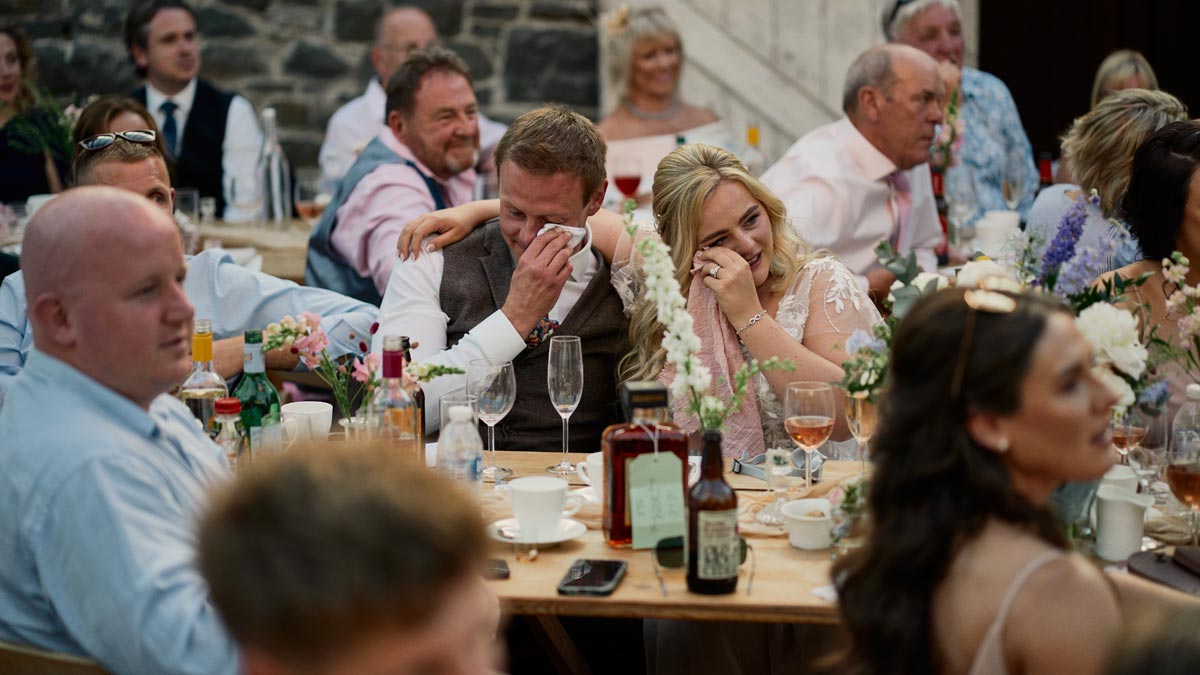 bride and groom crying during wedding speeches