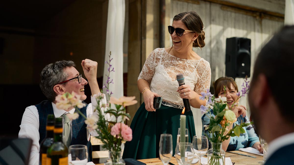 Bride wearing sunglasses makes her wedding speech